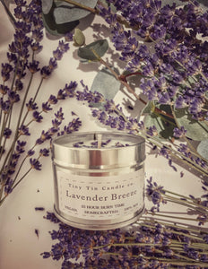 A homemade candle  Lavender Breeze scented candle from Tiny Tin Candle Co., displayed among fresh lavender sprigs, highlighting the natural, artisanal essence of the soy candle